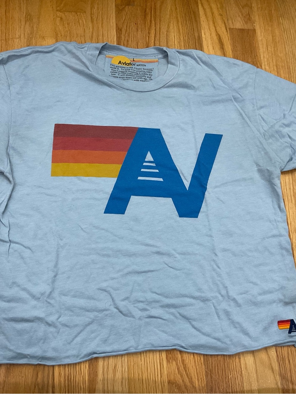 Aviator Nation Light Blue Tee with Blue Logo and Red-Orange-Yellow Stripe